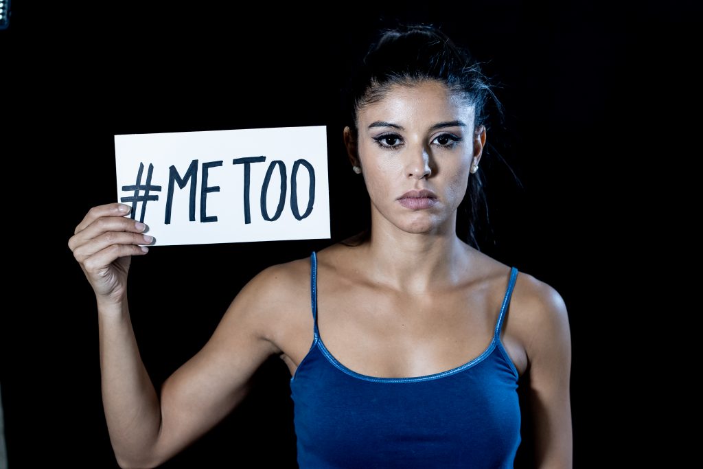 Na fotografia podemos ver uma mulher com um cartaz do movimento Me Too contra a violência sexual e a violência de género
